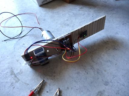 Elektronischer Aufbau mit Motor und Platine auf Holzbrett
