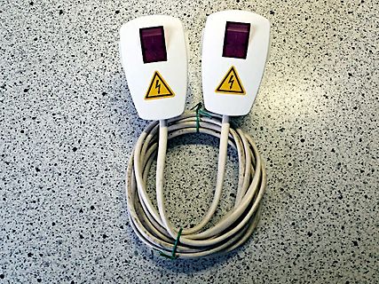 Zwei isolierte Handstücke mit Warnsymbolen und Kabel
