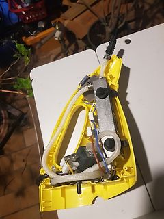 Innenansicht eines gelben Geräts mit Schläuchen und Bauteilen