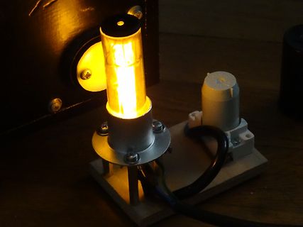 Aufbau mit leuchtender Röhre auf Holzbrett