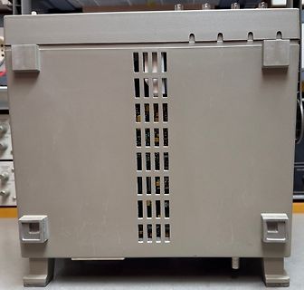 Rückseite eines grauen Elektronikgehäuses mit Lüftungsschlitzen