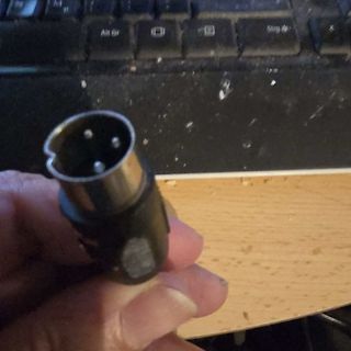 DIN-Stecker oder ähnlicher Rundstecker in der Hand