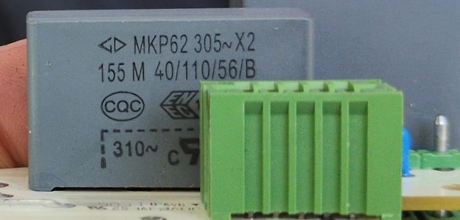 Nahaufnahme eines MKP62 Kondensators und eines grünen Steckers