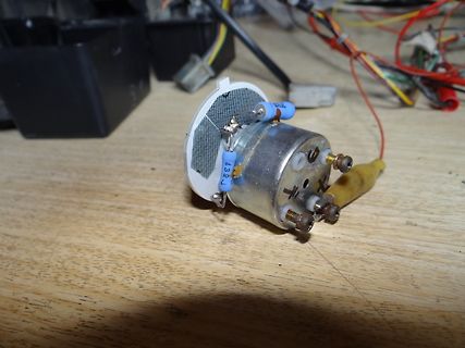 Elektromotor mit angeschlossenen Bauteilen auf Holzuntergrund