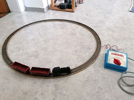 Modellbahnanlage mit Schienen, Zug und Trafo