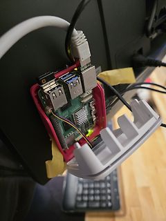 Raspberry Pi in pinkem Gehäuse an Monitor befestigt