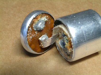 Geöffneter Elektrolytkondensator mit ausgelaufenem Elektrolyt