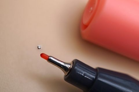 Nahaufnahme eines kleinen Bauteils und eines Markers