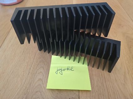 Zwei schwarze Kühlkörper auf Holzuntergrund