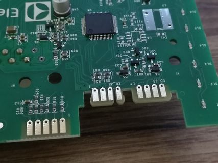 Nahaufnahme einer grünen Leiterplatte mit elektronischen Bauteilen