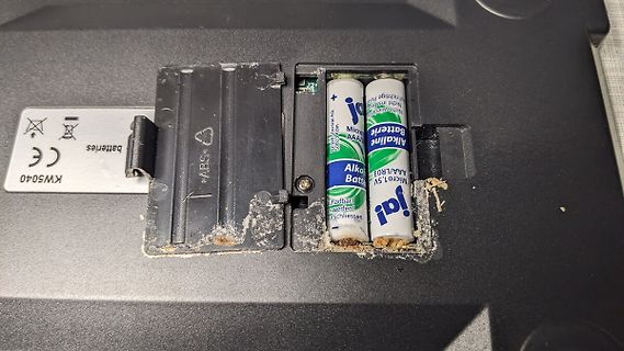 Batteriefach eines Geräts mit Batterien und Schmutz