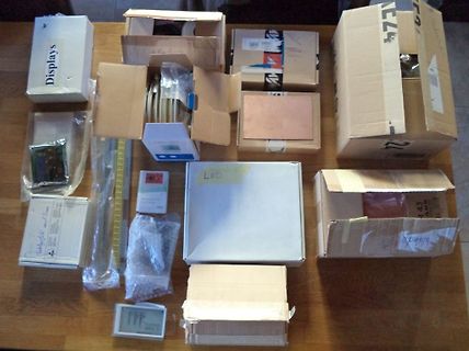 Verschiedene Kartons und Elektronikkomponenten auf einem Holztisch