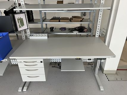 Arbeitsplatz in einer Werkstatt mit Schreibtisch und Regalen
