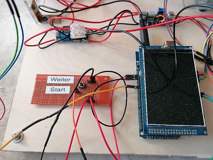 Elektronik-Prototyp auf Holzbrett mit Display und Lochrasterplatine