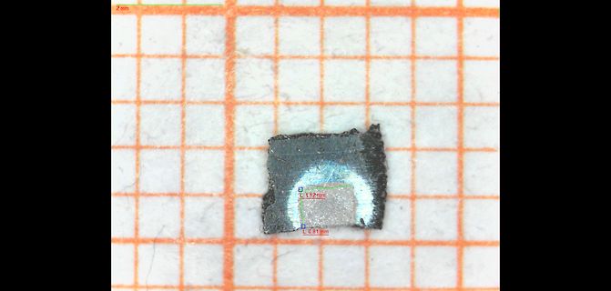 Mikroskopische Aufnahme eines Bauteils auf Millimeterpapier
