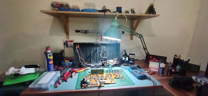 Elektronik-Werkstatt mit Leiterplatte, Multimeter und Werkzeugen
