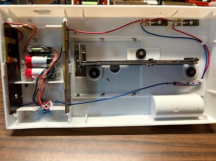 Innenansicht eines elektronischen Geräts mit Batteriefach und Verkabelung