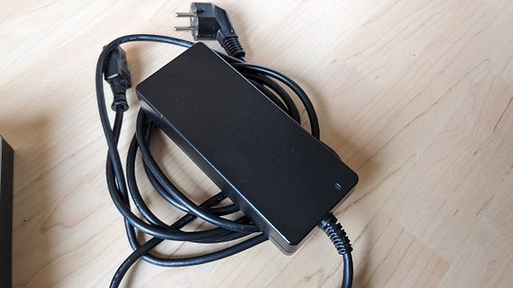 Netzteil mit Kabel auf Holztisch