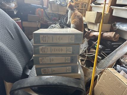 Stapel von Handbüchern eines Spektrum-Analysators mit Katze im Hintergrund