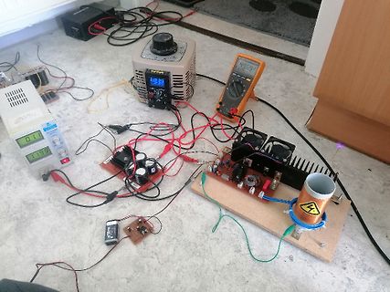 Elektronik-Versuchsaufbau mit Netzteil, Multimeter und Spule