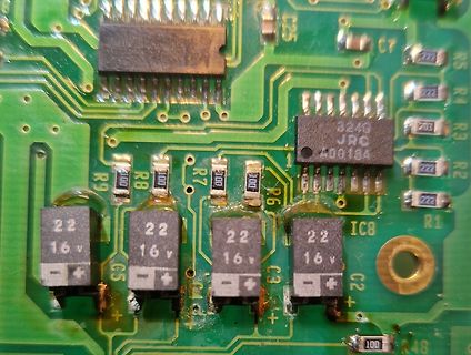 Nahaufnahme einer Leiterplatte mit Elektrolytkondensatoren und ICs