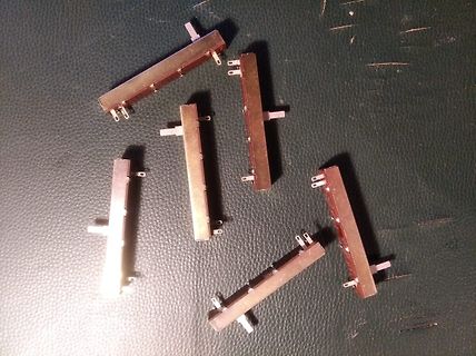 Mehrere metallische Bauteile auf dunklem Untergrund