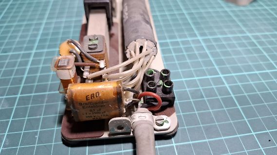 Elektronische Bauteile und Kondensator auf Werkstattunterlage