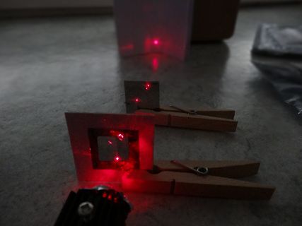 Experimenteller Aufbau mit Laserpunkten und Holzklammern