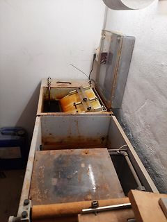 Verschmutzte Metallboxen und Gehäuseteile in einer Werkstatt