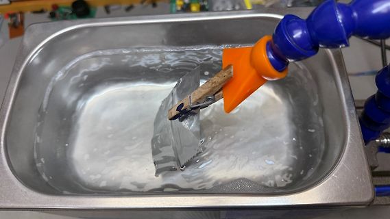Metallstück in einer Metallwanne mit Flüssigkeit