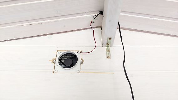 Lüfter in weißer Holzverkleidung mit Verkabelung