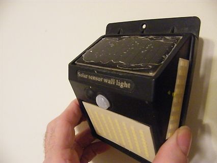 Solar-Sensor-Wandleuchte in der Hand
