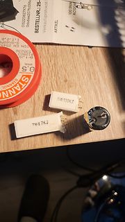 Elektronikbauteile und Lötzinn auf Holztisch