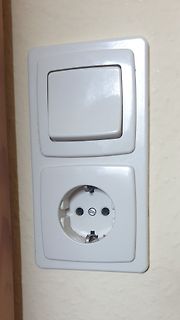 Lichtschalter und Steckdose an einer Wand