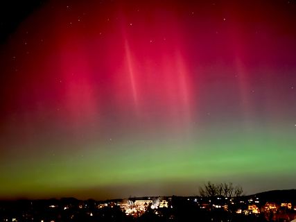 Polarlichter über einer Stadt bei Nacht