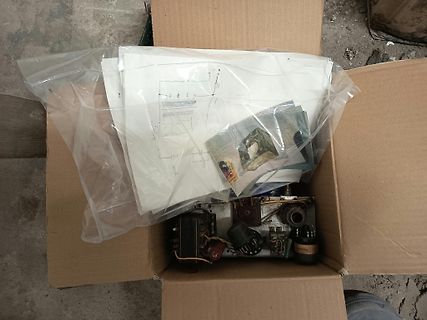 Schaltplan und Elektronikbauteile in einem Karton