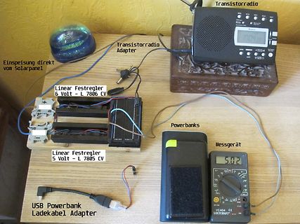 Elektronischer Aufbau mit Transistorradio, Spannungsreglern und Messgerät