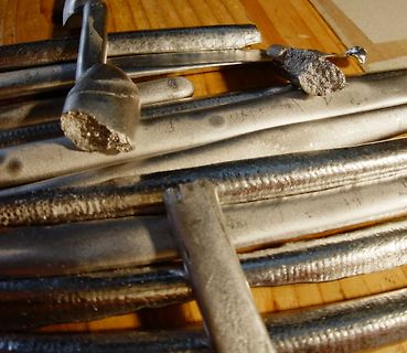 Abgebrochene Metallstäbe oder Kabel auf Holzuntergrund