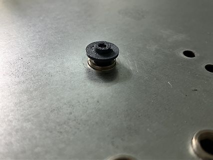 Schraube mit schwarzem Kunststoffring auf Metalloberfläche
