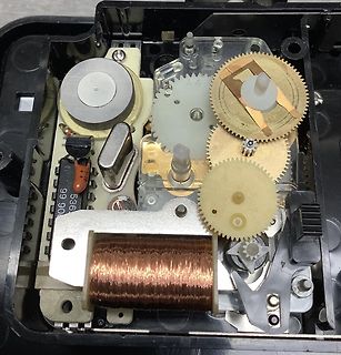 Innenansicht eines mechanischen Uhrwerks mit Zahnrädern und Spule