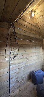 Holzwand mit hängenden Kabeln und einer Lampe