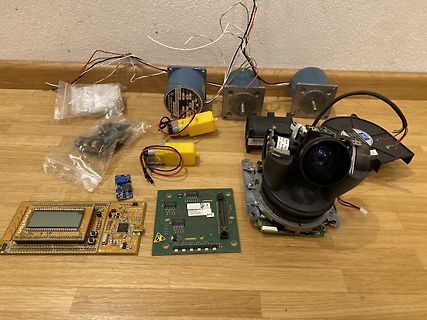 Diverse Elektronikkomponenten, Platinen und Motoren auf Holzboden
