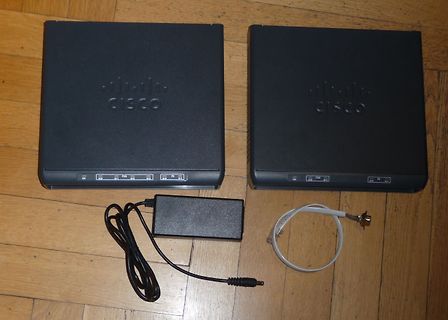 Zwei Cisco Geräte mit Netzteil und Kabel