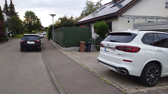 Zwei Autos auf einer Straße vor Wohnhäusern