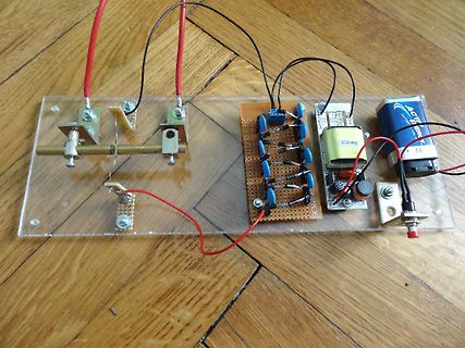 Elektronischer Aufbau auf Acrylplatte mit Batterie und Platine