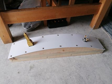 Holzaufbau mit weißer Platte und Metallstiften