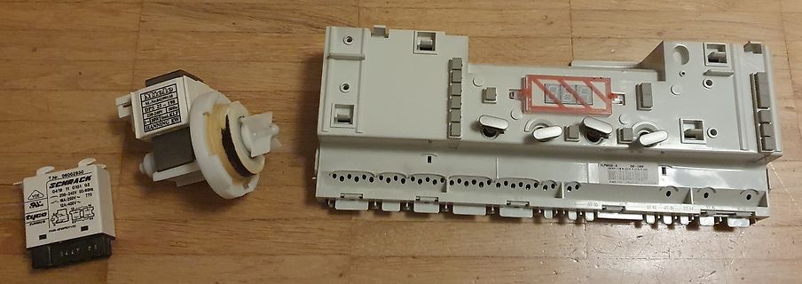 Elektronische Bauteile und Gehäuseteile auf Holzuntergrund