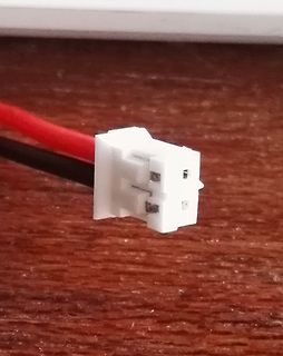 Weißer JST-Stecker mit roten und schwarzen Kabeln