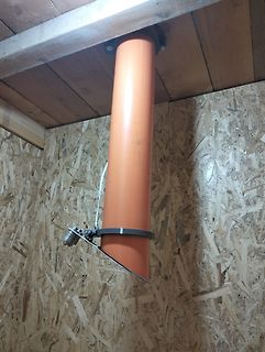 Orangefarbenes Rohr an Holzdecke und OSB-Wand