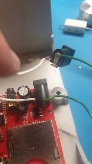 Geöffnete Elektronik mit roter Leiterplatte und Kabeln